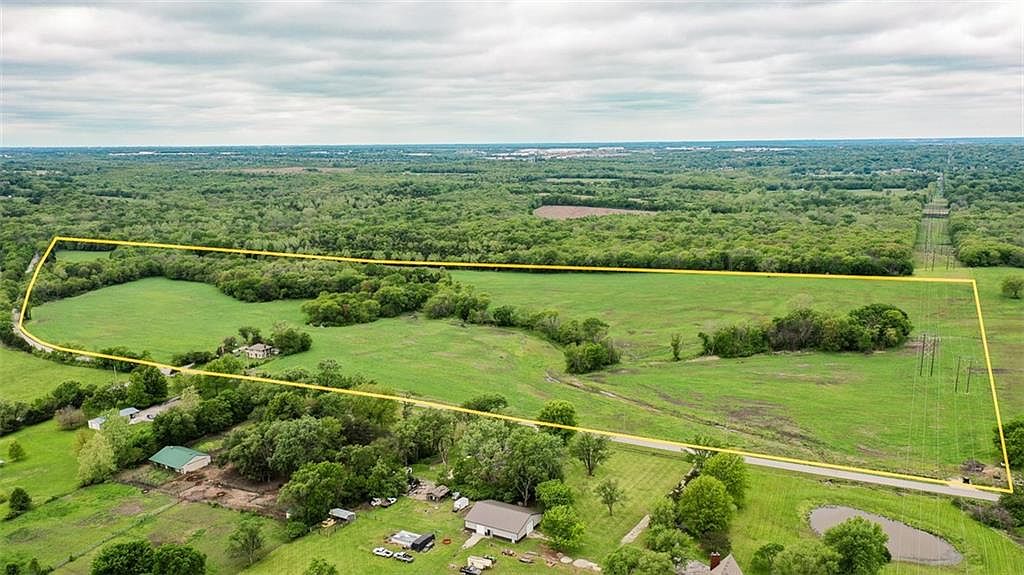 Aerial of the 80-acre tract with the property line drawn for orientation, Kansas City skyline on the horizon