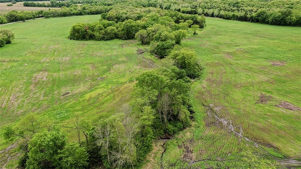 The small creek and timber pockets that slope across the parcel from north to south